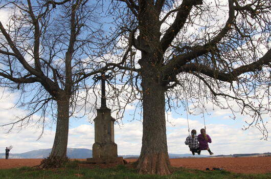 Houpačka u kříže mezi lány